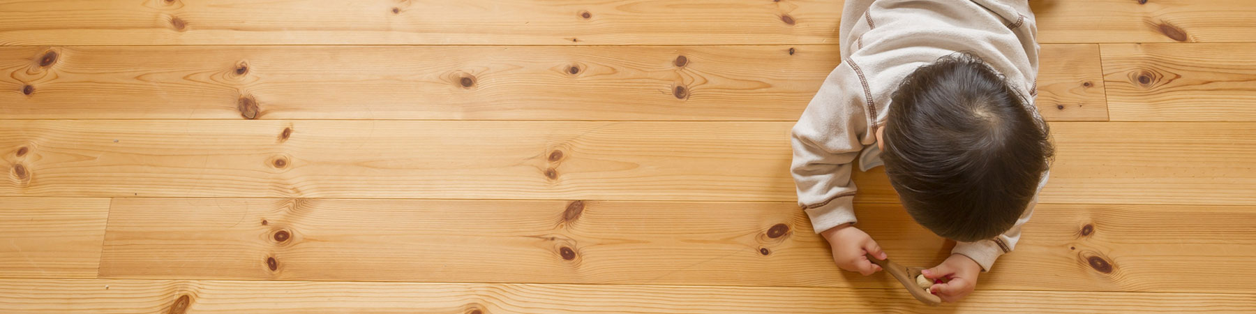 Kid Playing With Toy On Hardwood Flooring